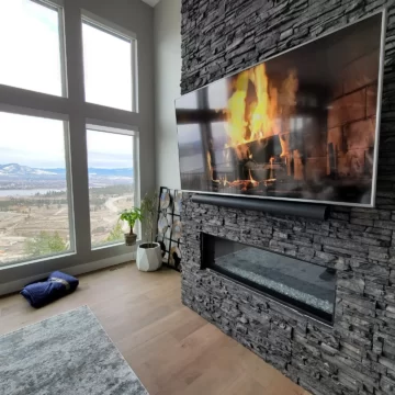 Custom wall mounted 4K television and soundbar above a fireplace by Mission AV in Kelowna, BC